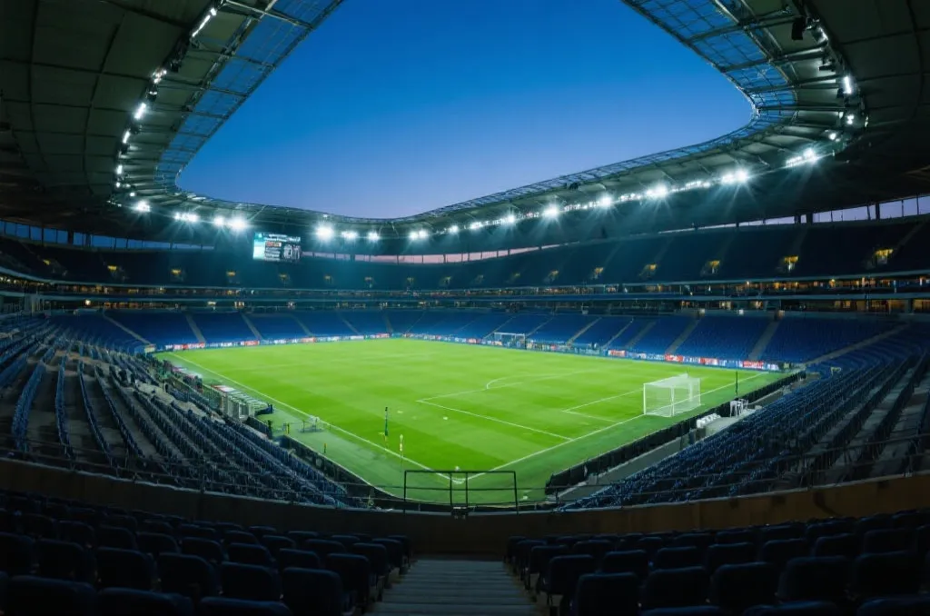 A modern soccer stadium interior with bright lights at dusk, professional stadium view
